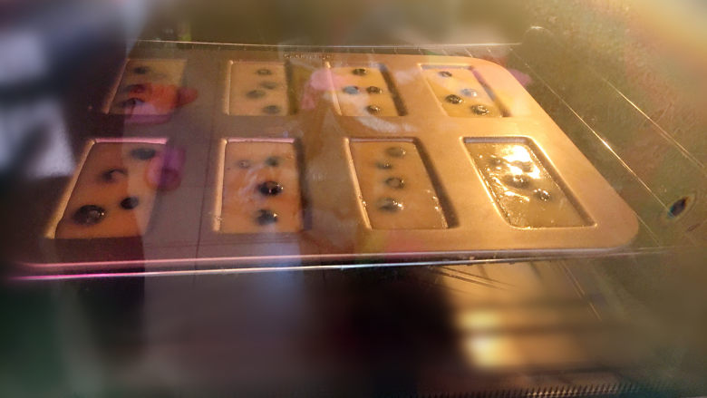 蓝莓费南雪,将学厨费南雪模具放入提前预热好的烤箱中，模具导热性很好，用180度15分钟左右就烤至表面金黄。