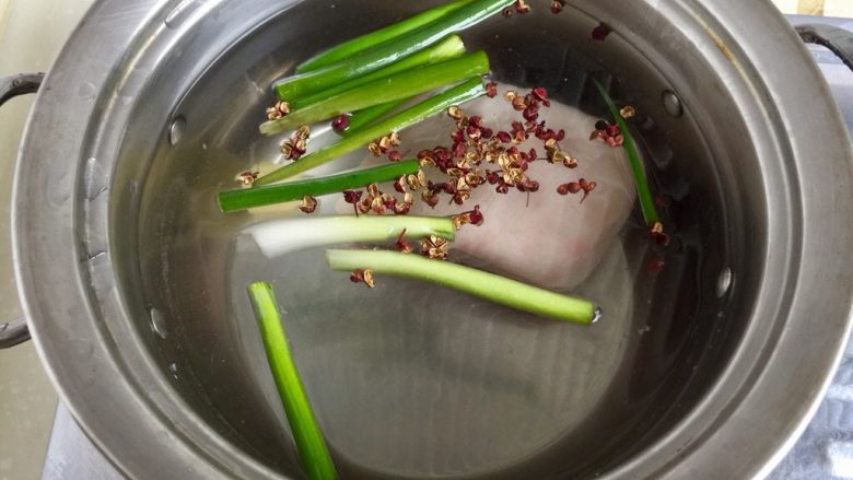 青笋回锅肉,锅中放清水葱段，花椒，姜，五花肉，中火