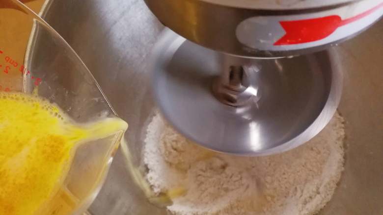 香浓卡布奇诺面包卷,将水料缓慢加入混合好的粉料中，揉至扩展阶段，就是能撑出膜就可以了，不用到完全阶段。