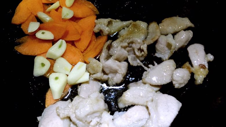黑木耳炒白菜,肉片变色后，放入蒜片和胡萝卜片翻炒几下