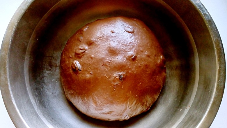 巧克力提子软欧包,继续揉1分钟，使提子干可以均匀的揉入到面团里，取出盖上保鲜膜进行基础发酵。