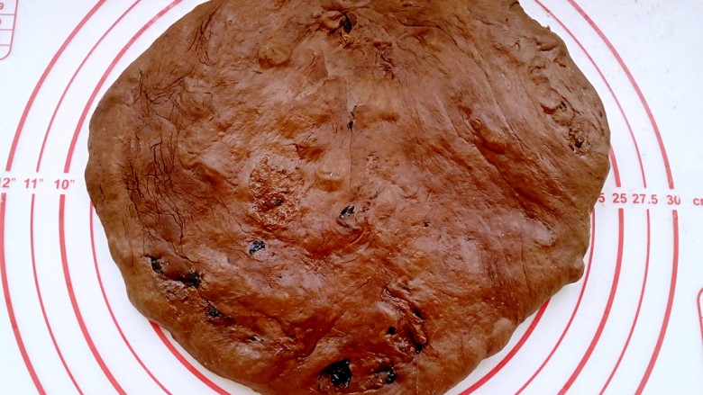 巧克力提子软欧包,发酵好的面团放在案板上排气。