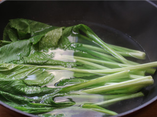 芥菜厚蛋烧,芥菜浸泡洗净，锅里烧开适量水，调入少量橄榄油，将芥菜焯熟后捞起，挤干水分