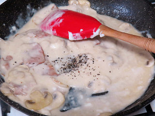 芝滋味浓滴【培根蘑菇白酱意面】,撒上黑胡椒粉及盐搅拌均匀
