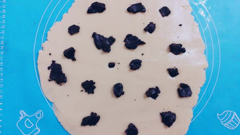 炼奶双色小饼干,在擀好的面皮上，放入大小不等的可可面团