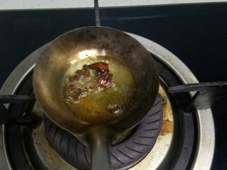 糊涂大米,勺子里放入适量油，小火炒香花椒、茴香。