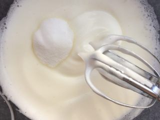 大理石戚风蛋糕,蛋白打发至湿性发泡，即提起打蛋头出现大的弯勾时，第三次加入细砂糖。 