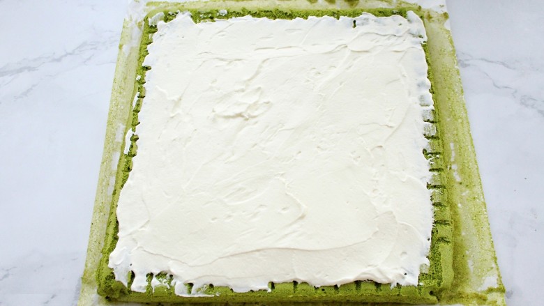 抹茶奶油蛋糕卷,将打发的淡奶油涂抹到蛋糕片上