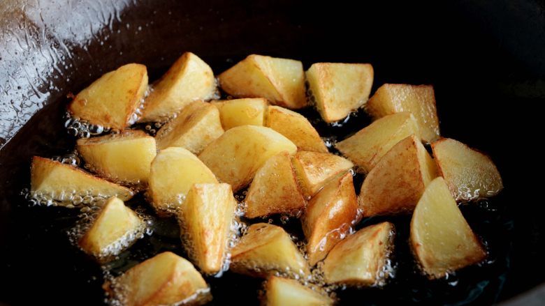 『土豆茄子煲』,锅内倒入色拉油，油热后倒入土豆炸至金黄色