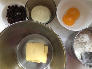 葡萄干奶酥,准备好全部材料，奶粉和糖混合一起，葡萄干剪成一半