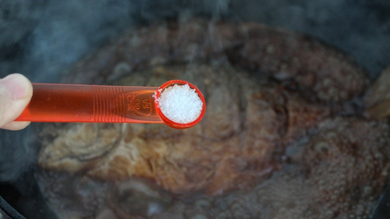 红烧鲳鱼,按口味调入盐，用勺子舀起汤汁浇到鱼身上