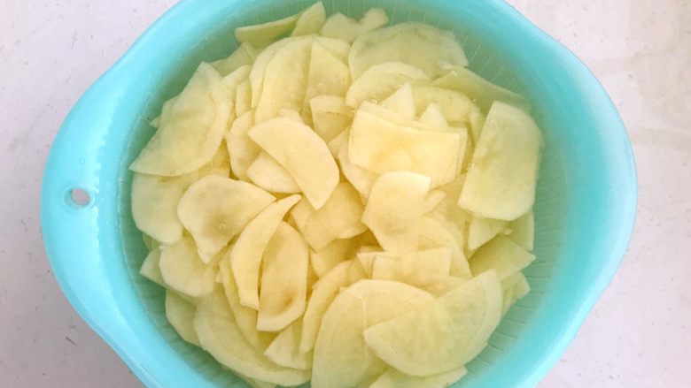 快手菜-腊肉土豆片,把土豆片放入冷水中清洗2次，洗去多余的淀粉