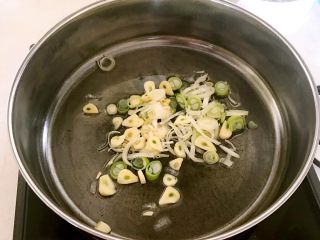 快手菜-腊肉土豆片,锅里加入大豆色拉油烧热后加入葱花和蒜片，翻炒出香味