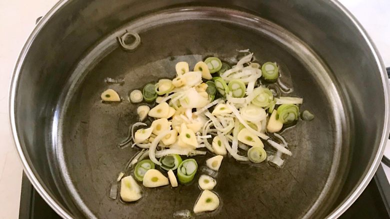 快手菜-腊肉土豆片,锅里加入大豆色拉油烧热后加入葱花和蒜片，翻炒出香味