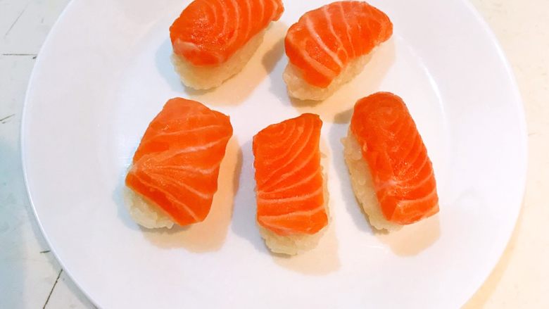 三文鱼寿司,在长条饭团上面放上三文鱼，三文鱼寿司做好了