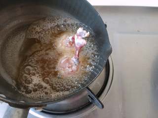黄金翅根“棒棒糖”,之前炸蒜酥的油倒回锅中，中小火至油温6、7成热时将翅根竖着放入