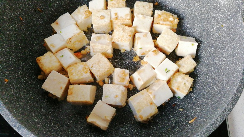 橄榄菜肉末豆腐盖浇饭,再下入豆腐块小火煎至两面金黄；