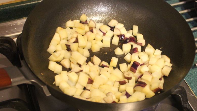 土豆烧茄子,将土豆、茄子同时入锅，中火炒至土豆表面微变透白。