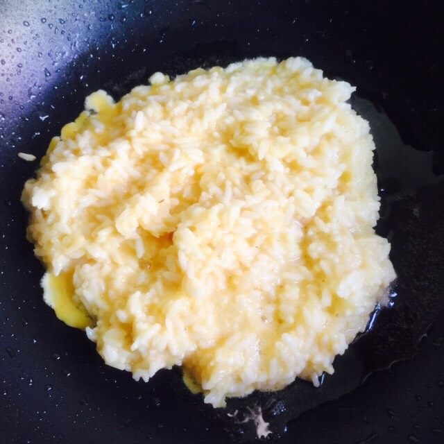 培根黄金蛋炒饭,将拌匀的米饭倒入锅里快速翻炒