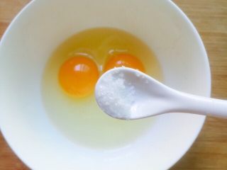 培根黄金蛋炒饭,将鸡蛋打入碗里加少许盐