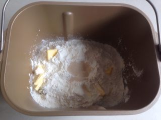 红糖红薯面包,加入奶粉、面粉和切成小块的黄油，在面粉顶端加入酵母