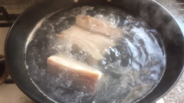 红烧肉焖四季豆,锅中放入适量水烧开煮肉。