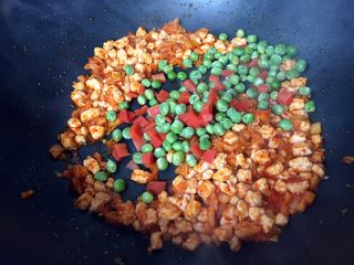炒饭秀+辣白菜炒饭,倒入煮熟的胡萝卜和豌豆翻炒均匀。