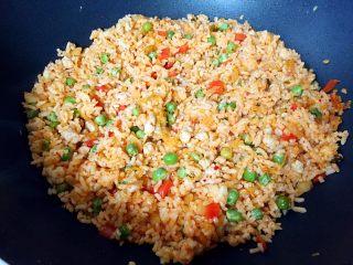 炒饭秀+辣白菜炒饭,大约翻炒1分钟让米饭均匀裹上辣白菜的颜色。