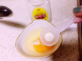 虾仁什锦蛋炒饭,第一步鸡蛋打入碗，如图放少许调味盐