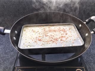 蒸肠粉,锅中倒入适量水烧开后，添加了米浆的蒸盘放锅中。