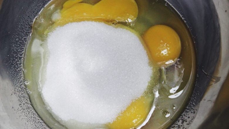 圣诞玛德琳,将蛋和细砂糖倒入到盆子里，搅拌至细沙糖完全融化。