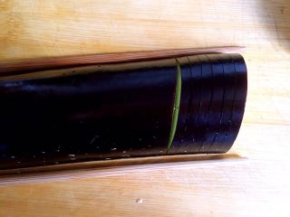 茄汁灯笼茄子,取一双筷子放在其中半根茄子两旁，切六刀，前五刀不切断，切第六刀时拿走筷子，切断
