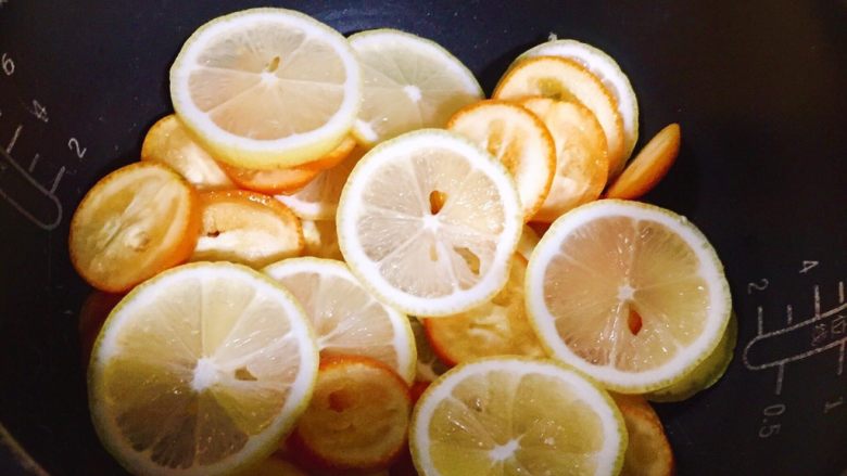冰糖柠檬金橘膏
,在电饭锅中放入一层去籽的柠檬金橘片。