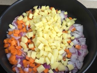 腊肉饭,放入土豆和胡萝卜，翻炒3分钟左右