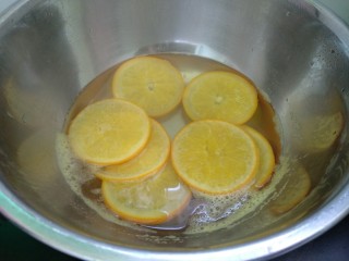 香橙蛋糕卷,橙子洗净切成2-3毫米薄片。橙子放入锅里加适量清水和30克白糖，将橙子煮至橙子白色部分变软透明，捞出沥干水分。（橙子糖水放凉备用）