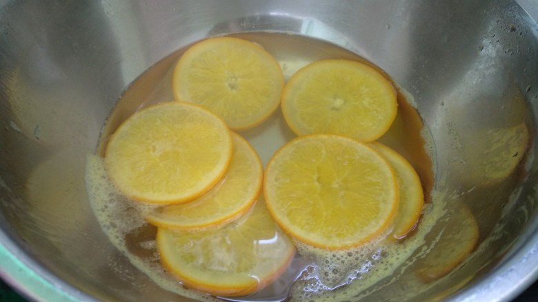 香橙蛋糕卷,橙子洗净切成2-3毫米薄片。橙子放入锅里加适量清水和30克<a style='color:red;display:inline-block;' href='/shicai/ 3729'>白糖</a>，将橙子煮至橙子白色部分变软透明，捞出沥干水分。（橙子糖水放凉备用）