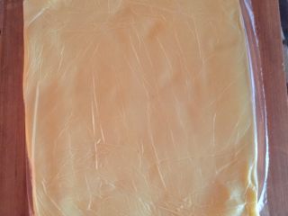 丹麦吐司（开酥吐司）,黄油室温软化好之后装入保鲜袋擀成薄片，大概20乘以18那么大小就可以了，然后放入冰箱冷藏