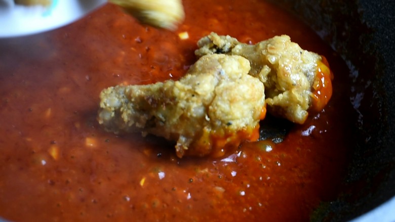 辣酱炸鸡,酱汁炒至起小泡泡后，倒入炸好的鸡翅、翅根