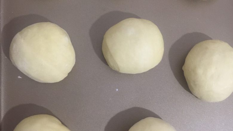 奶香红薯排包,稍微滚圆的面团放入烤盘中放进发酵箱开始松弛20分钟