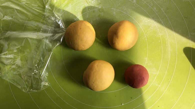 莎莉鸡豆沙包,取出发酵好的面团，分成三大一小的面团，其中小的面团加入红曲粉揉匀成橘黄色