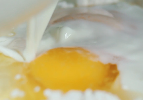 意大利手工水饺,拿个碗，倒入面粉，打两个鸡蛋进去，加盐和牛奶，和匀。
