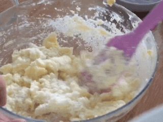 椰蓉小酥球,加入椰蓉，用刮刀按压均匀，让椰蓉和黄油霜充分混合；