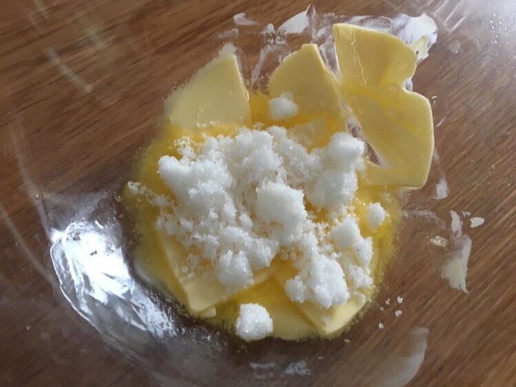 椰蓉小酥球,细砂糖加入软化的黄油，为了防止砂糖四溅，可以先用刮刀把糖和黄油压匀。