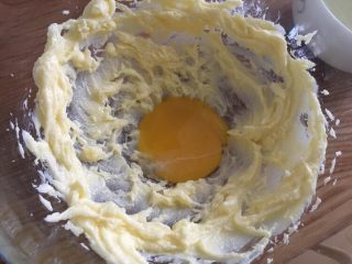 椰蓉小酥球,黄油霜里加入蛋黄继续打发均匀；