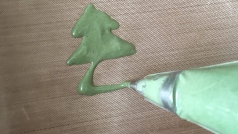 圣诞树蛋糕卷,拌匀的绿色蛋糕糊，装入裱花袋，挤出三角形叠加。