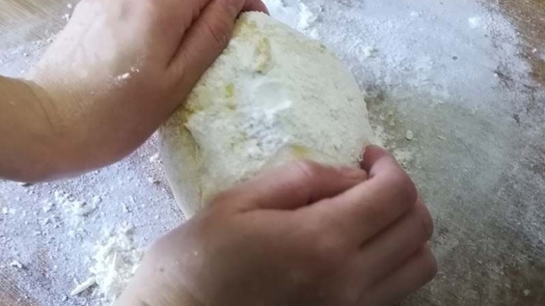 萌萌的小黄人卡通果蔬馒头,拿出面团，在案板上反复按压排气，一边揉一边裹入干面粉，这个步骤是馒头光滑的关键，必不可少。