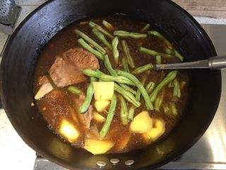 东北·乱炖,用大铁锅盛出骨头汤和一块带肉比较多的骨头，煮开，加入豆角和土豆，盖上盖子先炖熟豆角和土豆