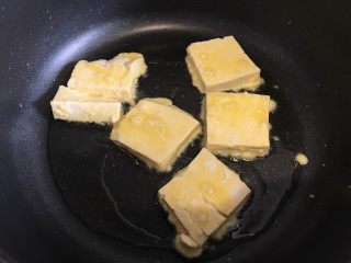 山东·锅塌豆腐,豆腐先在玉米淀粉里两面裹上一层淀粉，然后再鸡蛋液里滚一圈，锅内下食用油，热稍微热后下豆腐煎