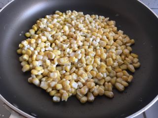 玉米烙,将玉米粒倒入锅中压平
