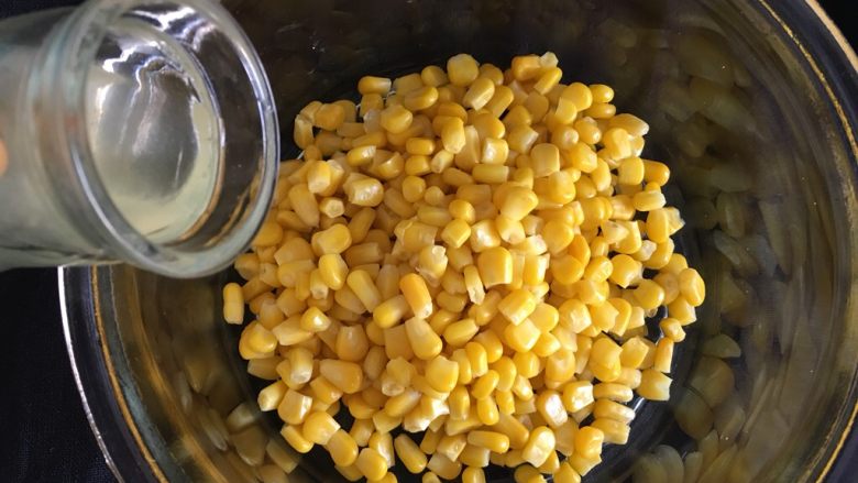 玉米烙,刚才煮沸的汤水挖入小半勺，让每粒玉米粒上沾上水